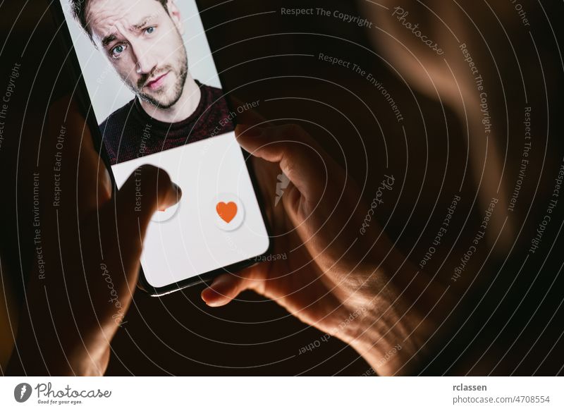 Woman giving a like to photo on social media or swiping on online dating app. Finger pushing heart icon on screen in smartphone application. Friend, follower or fan liking picture of a beautiful man.
