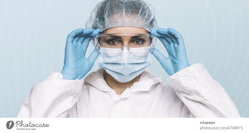 Female Doctor or Nurse Wearing latex protective gloves and medical Protective Mask and glasses on face. Protection for Coronavirus COVID-19 nurse doctor mask