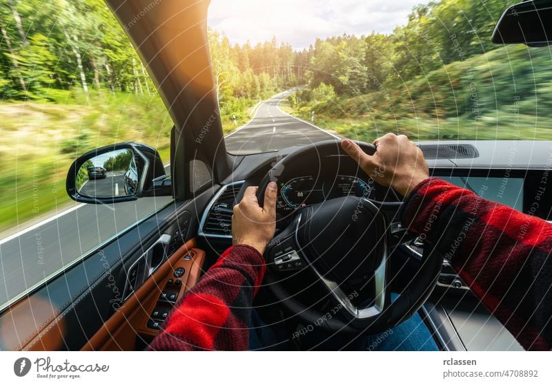 hands of car driver on steering wheel, road trip, driving on highway road curve inside asphalt dashboard day europe evening first person front getaway interior