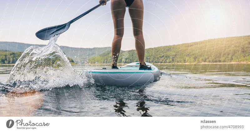 Sporty girl stand up paddle surfing board lake paddleboard sport water adventure sup woman water sport recreation travel fun activity lifestyle ocean surfboard