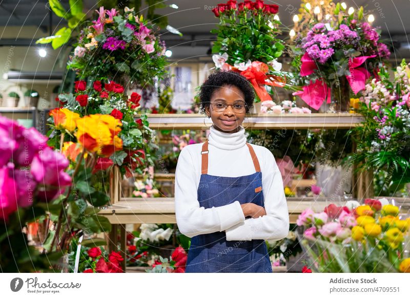 Cheerful black woman in flower shop floral shop bouquet florist work plant floristry industry professional store job female small business african american