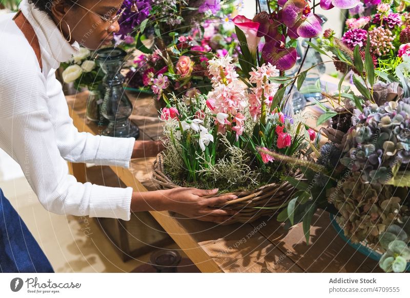 Black woman with flowers in basket floral shop galanthus hyacinth florist work plant floristry bouquet industry professional store job female small business