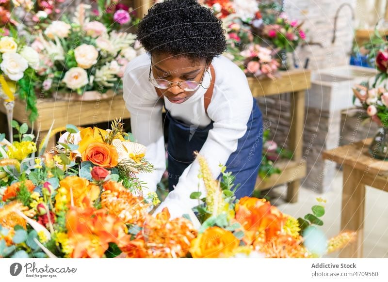 Black woman with flowers in floral shop worker bouquet florist plant floristry industry bloom blossom employee professional store job female small business vase