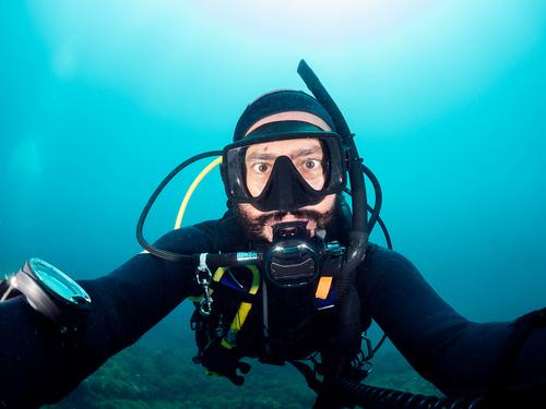 Diver in snorkeling mask taking selfie underwater man diver self portrait sea hobby male wetsuit swim deep aqua activity undersea ocean light extreme sporty