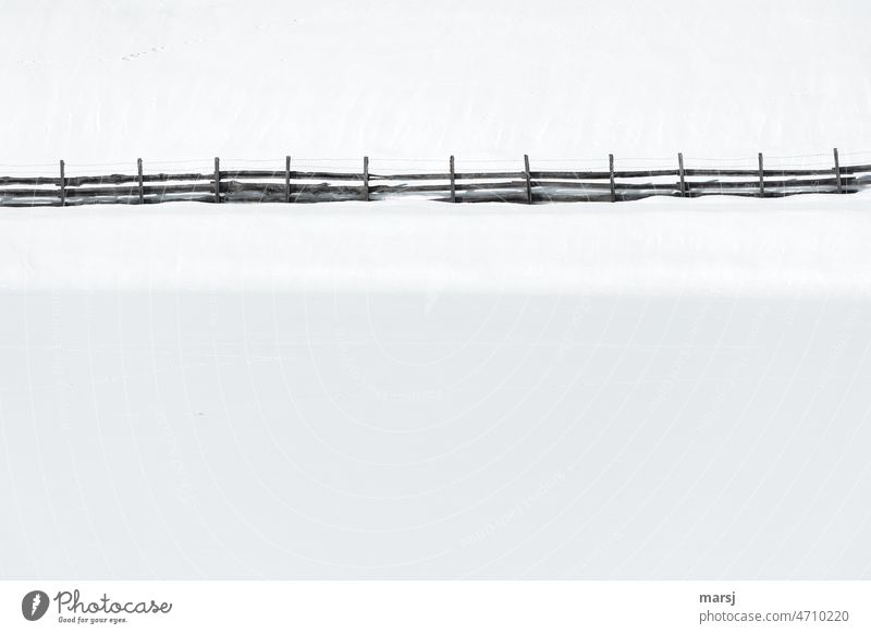 Wooden fence. Border, separates, protects, divides. In front a snow-covered pond, behind a snow-covered slope. Fence Snow Winter Morning Day Cold Nature