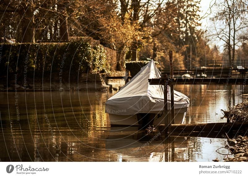 Boat at jetty in canal boat Footbridge Channel Water Back-light Watercraft Exterior shot reflection trees Spring Surface of water Deserted Reflection Calm