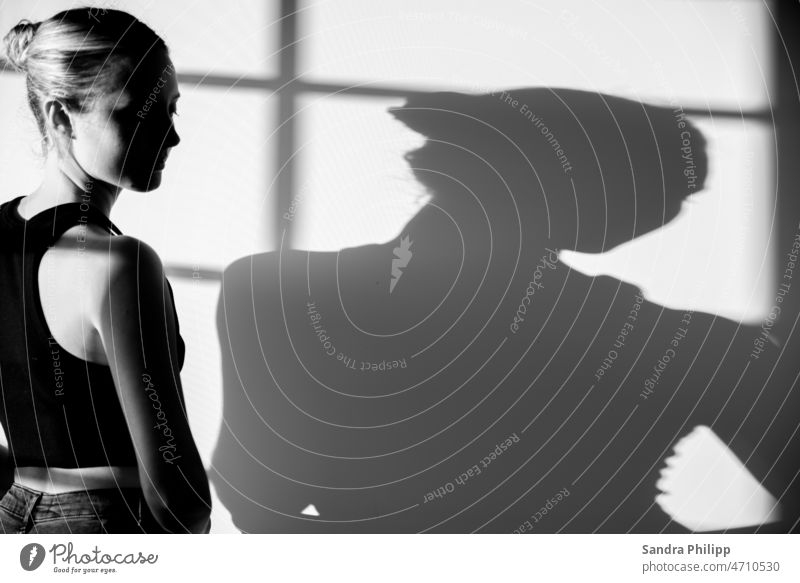 Young woman and her shadow in black and white Shadow Light and shadow Contrast Sunlight Shadow play Silhouette Structures and shapes Abstract Girl