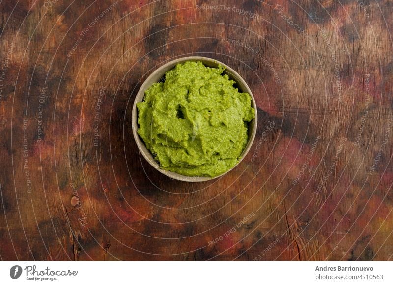 Bowl of freshly prepared fresh guacamole on a wooden background in brown tones. Healthy food rich in omega 3 fats that help prevent cholesterol. Super food.