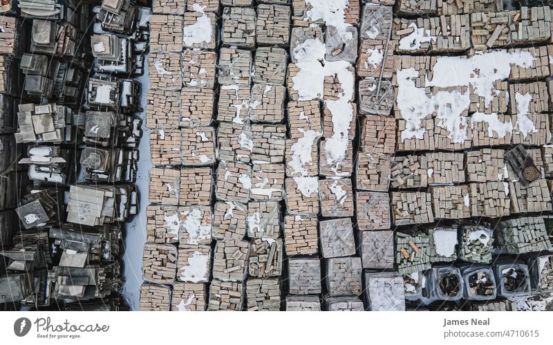 Rows of snow covered landscaping materials group of objects rock construction industry line decorative gardening aerial view stone material landscaped warehouse