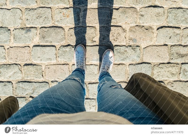 Young woman stands cobblestones, personal pespective from above. pov people lifestyle point view way caucasian young first person view point of view perspective