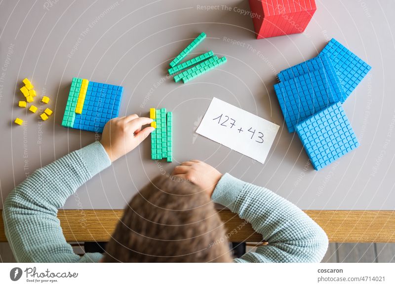 Little boy using the base 10 method to do addition at home abacus abobe alone blocks child childhood children colorful concept counting cute decimal education