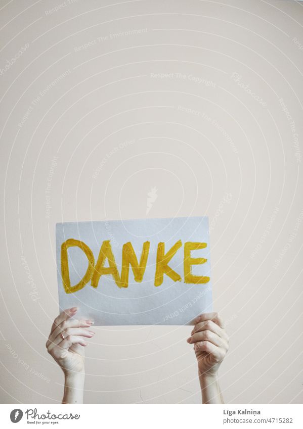 Person holding paper with word danke written with yellow letters Word Characters Typography Text writing Language Communicate Communication communication Danke