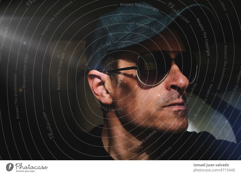 adult man with cap and sunglasses taking a selfie in the shadows one person portrait forty forties face head male 40 years daytime casual style free time