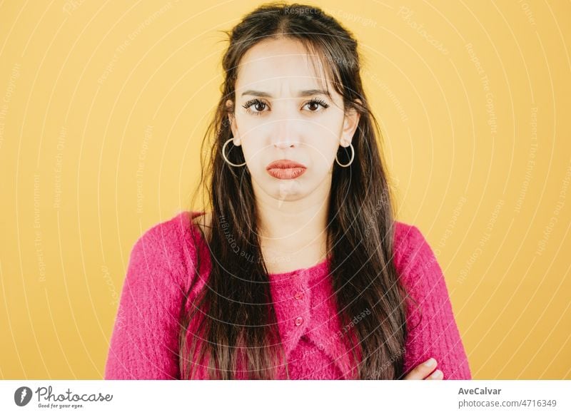 Young african woman looking to camera sad and worried about something mental health concept concept posing isolated over yellow color wall background. Daily expressions with copy space in studio.