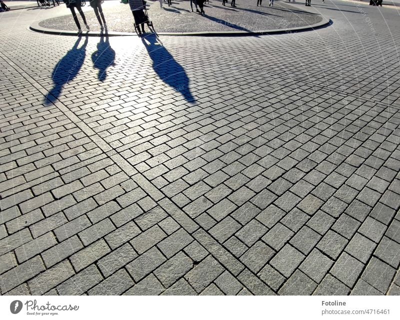 Shadow worlds IV - On a square passers-by cast long shadows on the paving stones Light Light and shadow Sunlight Contrast Shadow play Exterior shot Day