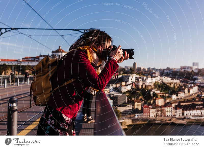 woman in Porto bridge taking pictures with camera at sunset. Tourism in city Europe. travel porto tourist enjoy 30s relax holidays vacation urban high