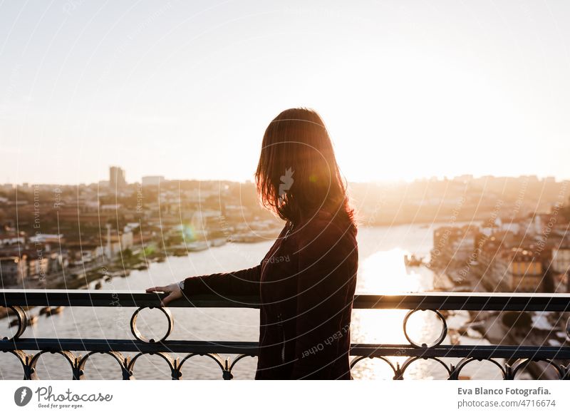 back view of relaxed woman in Porto bridge at sunset. Tourism in city Europe. travel and lifestyle porto tourist enjoy 30s holidays vacation urban high