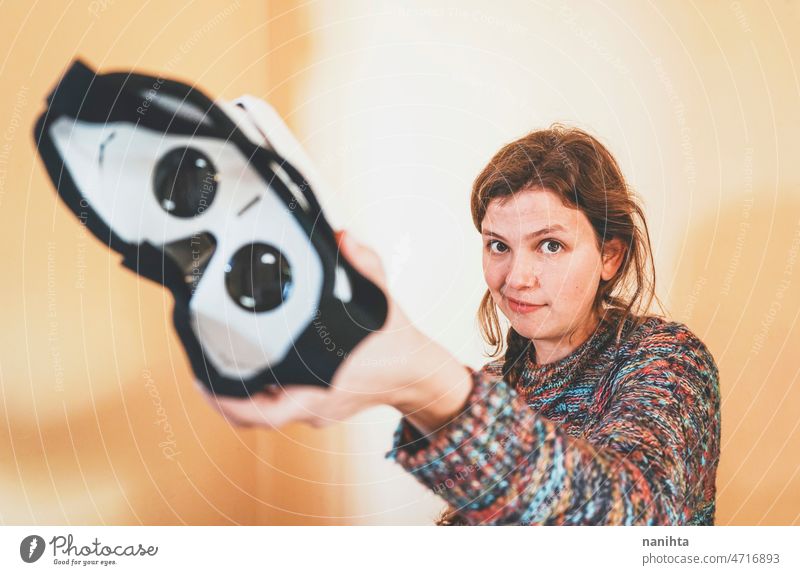 Forced perspective image of a young woman holding the lenses of a vr glasses of cardboard metaverse inside technology sustainability playful gamer weird nerd