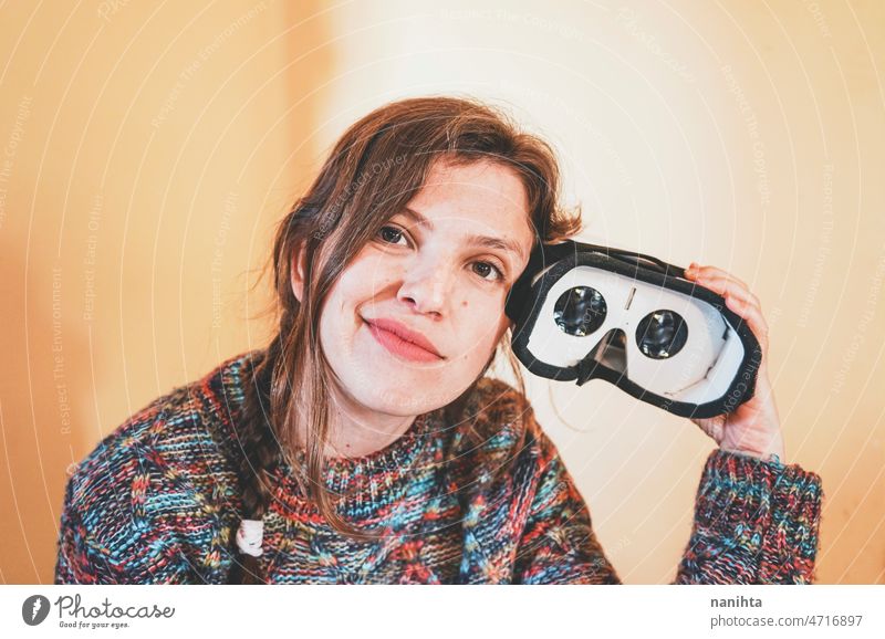 Funny portrait of a young woman holding a cardboard vr glasses metaverse inside lens technology sustainability playful gamer perspective weird nerd nerdy