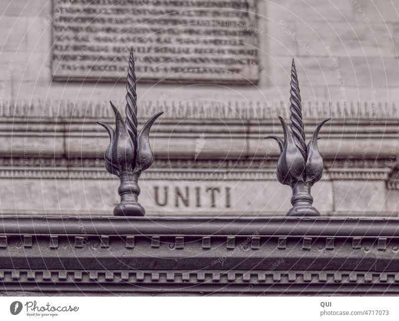 UNITI lettering behind wrought iron fence spikes Wrought ironwork Goal Old Iron Metal Craft (trade) Historic Agreed silver Architecture Wall (building)