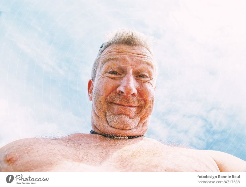 Unshaven hairy man with bare upper body and double chin from under view on beach Man Colour photo 50 - 60 year Face camera view portrait man's breast