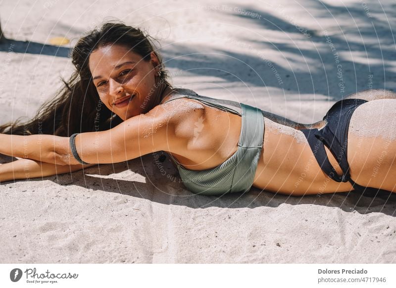 Female model posing in a bikini lying on the sand of a heavenly beach attractive background banner beautiful beauty body brunette caucasian fashion female
