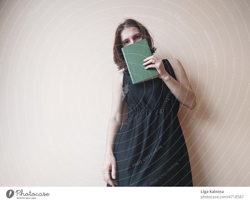 Woman holding book in front of face Book Young woman Reading matter Novel Literature Information School Paper Academic studies Page books Know Education