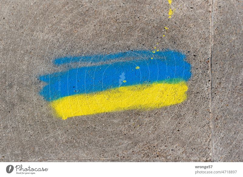 Blue and yellow colors sprayed on gray concrete as a sign of solidarity with Ukraine Blue-yellow Sign Solidarity War Peace Politics and state Hope