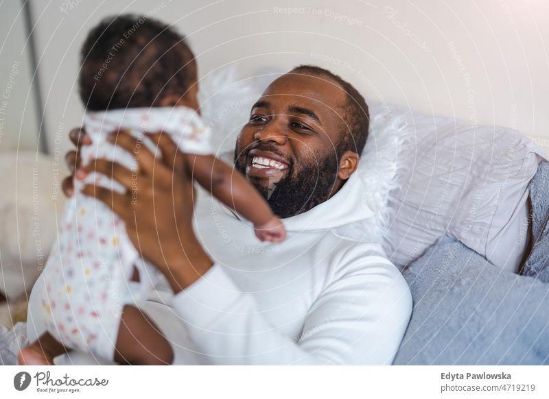 Father playing with his little baby girl at home father dad kids child newborn family fatherhood real people indoors house flat apartment enjoy adult authentic