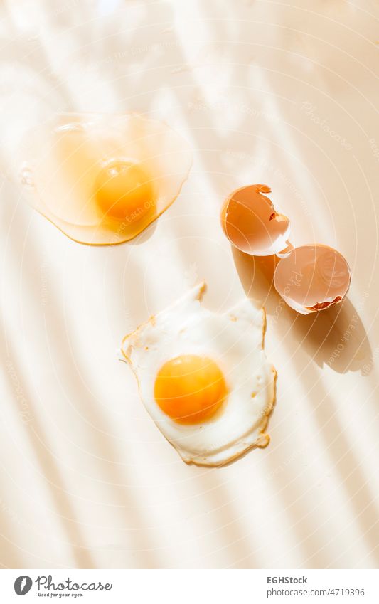 Raw egg, fried egg and cracked eggshell raw pattern present past future fry nutrition cholesterol burnt product fragile life heat no people healthy lifestyle
