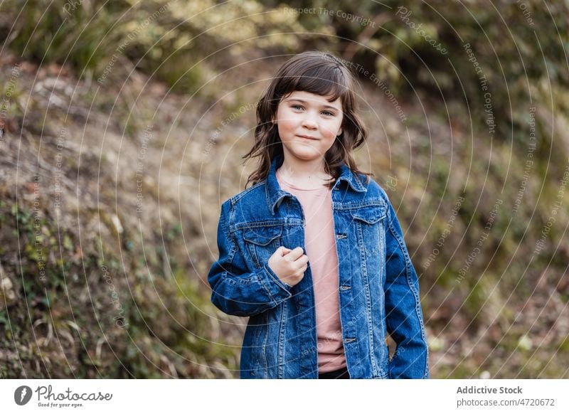 Charming girl in denim jacket in nature appearance child carefree individuality positive portrait countryside childhood charming cute pleasant kid curious