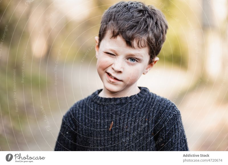 Boy in warm sweater winking at camera boy child portrait personality coquette individuality charming glance playful funny childhood little cute feature kid
