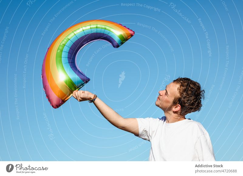 Cheerful man with LGBT balloon transgender lgbt lgbtq rainbow identity freedom equal gay homosexual pride tolerance symbol cheerful identify joy happy male