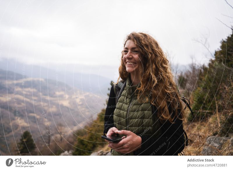 Cheerful woman with smartphone on mountain traveler hiker highland trekking nature adventure journey explore activity trip wanderlust slope explorer tourist