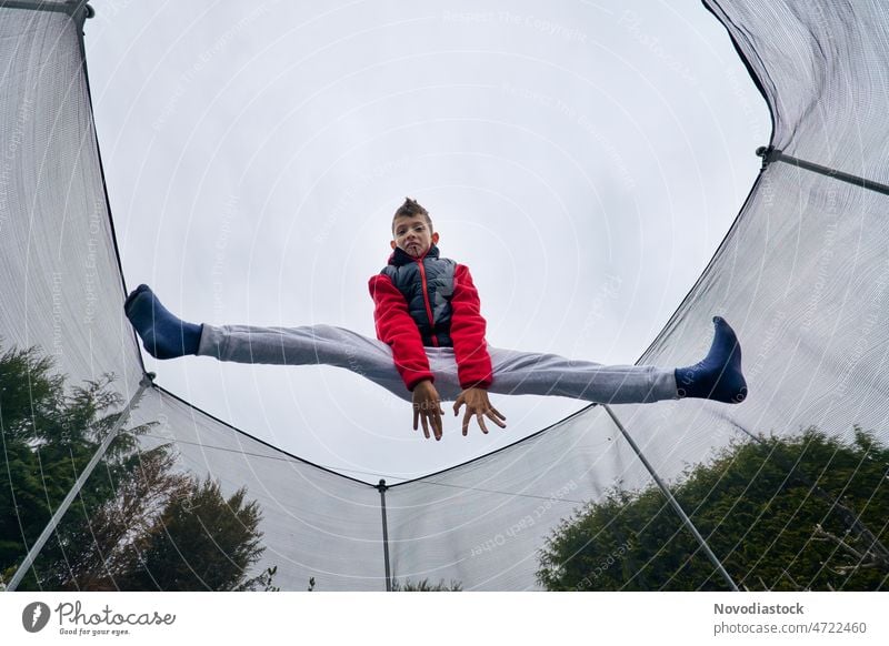 Portrait of a 9 year old boy jumping on a trampoline high young fun portrait caucasian active lifestyle one isolated happy legs outdoors body joy leisure