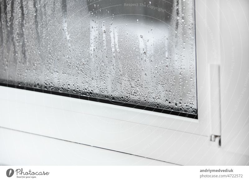 a plastic window with condensation of water on the glass. Double glazed PVC window. Concept: defective plastic window with condensation, temperature difference, cooling, humidity in the room.