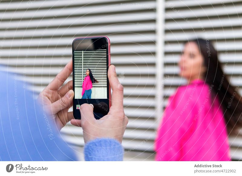 Faceless person taking photo of Hispanic woman take photo photographer smartphone street capture wall photography style feminine screen moment memory gadget