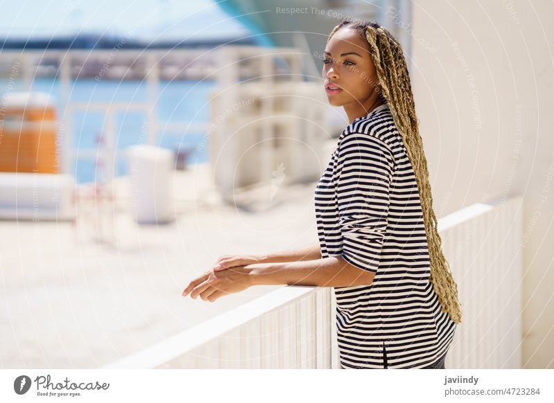 Young black woman enjoying the view of the seaport. girl lifestyle female happy coast smile tourism holiday travel summer beautiful cheerful young attractive