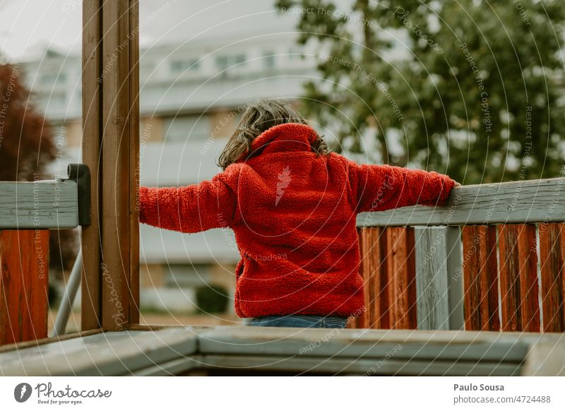 Rear view girl with red jacket on playground Red Child childhood Girl Childhood memory Colour photo Infancy Day Exterior shot Human being Multicoloured Cute Joy