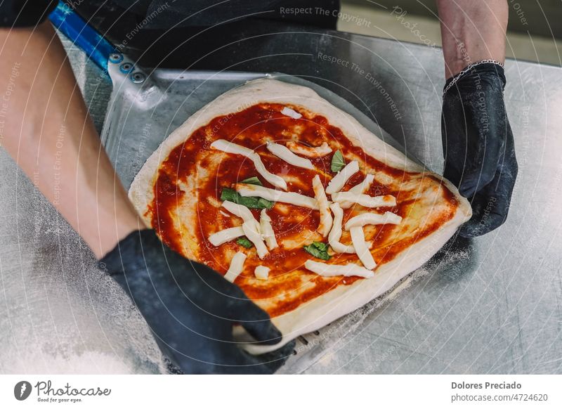 Preparation of a homemade Italian style pizza by a specialist bake baker bakery cheese chef cook cookery cooking cuisine culinary dish dough eat flour food hand