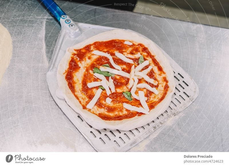 Preparation of a homemade Italian style pizza by a specialist bake baker bakery cheese chef cook cookery cooking cuisine culinary dish dough eat flour food hand