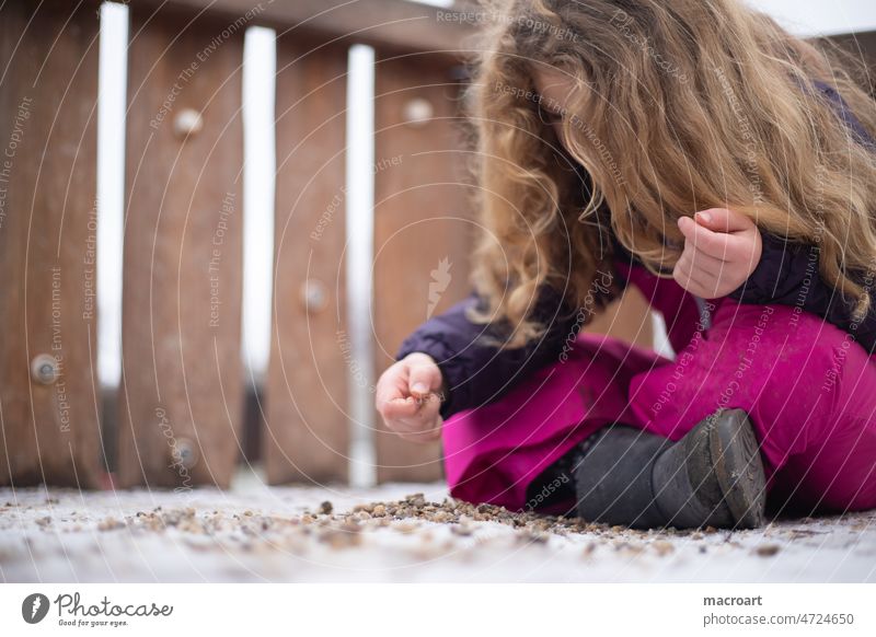Child playing with stones Blonde Curl lured Playing steihne Cold Pink Winter hands Fingers person feminine Girl pink purple winter sad boringly Boredom