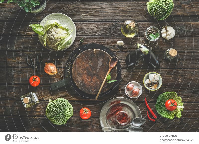 Various raw vegetables and  utensils on rustic wooden kitchen table. Healthy cooking food background frame various kitchen utensils cauliflower savoy cabbage