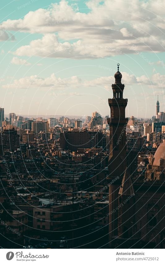 Vertical shot of Cairo rooftops, view from the Salah Al Din castle area. Mosqsue minaret in front, huge city and buildings going into the distance medieval