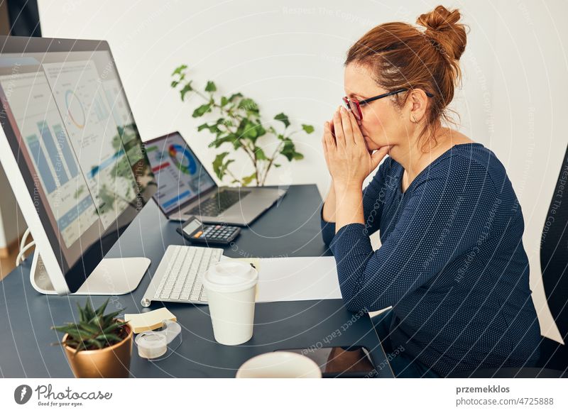 Stressed woman entrepreneur focused on solving difficult work. Confused businesswoman thinking hard looking at numbers and charts on screen frustration problem