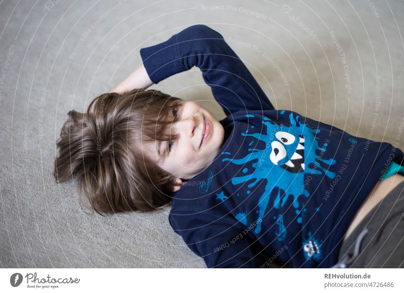 happy child lying on the floor Boy (child) Playing portrait Cute 7 years Child Human being cheerful Smiling fortunate pretty naturally Romp Funny Laughter