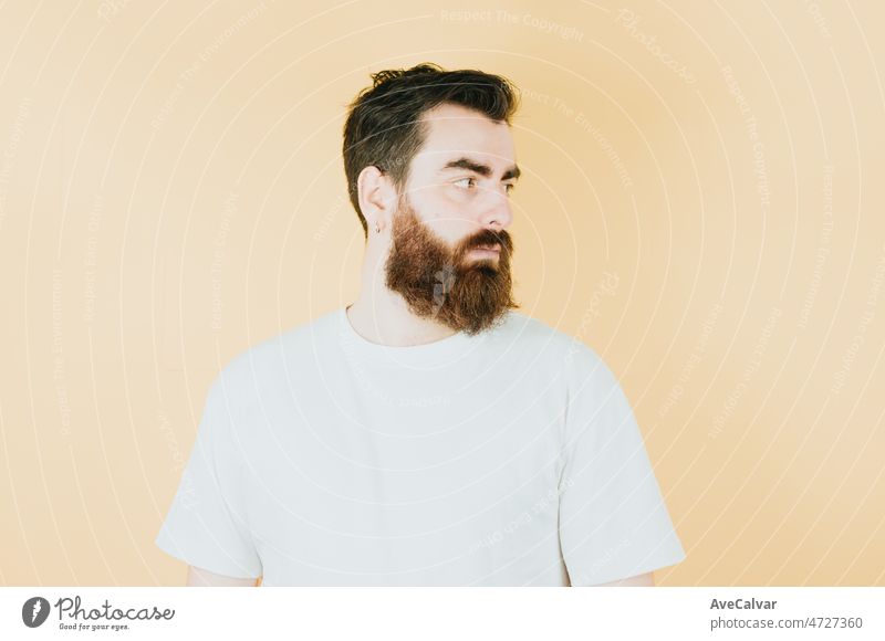 Handsome hipster bearded looking out of camera serious, mental health concept. Young man attitude funny. Soft tone color background, expression of normal people. Mockup concept with people