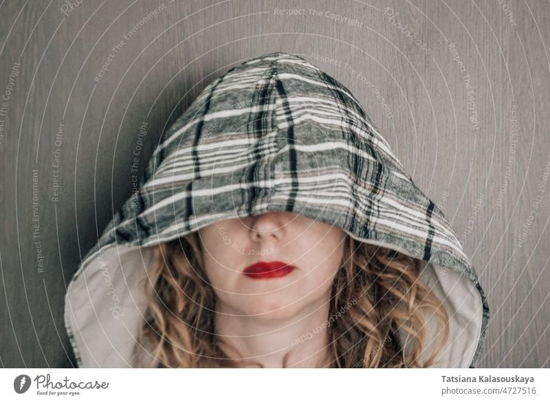 Curly woman with a hood on her head covering her eyes Horizontal Photography Hood - Clothing Portrait One Person Front View Looking At Camera Beautiful Woman