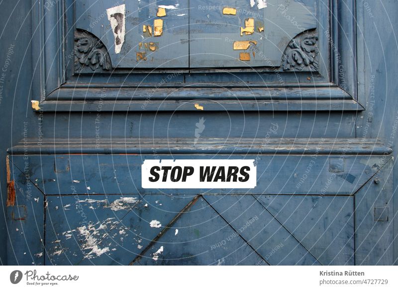 stop wars sticker on old wooden door War Stop Quit Peace world peace pacifism Global International utopia non-violence pacifist non-violent demand call please