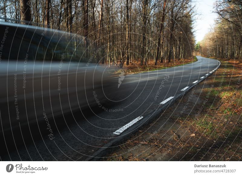 A car driving fast on a road through the forest speed transportation motion asphalt travel blur drive highway traffic blurred auto automobile vehicle danger